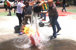 VP for Administration Rev. Fr Rouel Sia, OAR tries to put-out fire using a pail of water relayed by other employees.