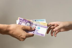 hand-holding-giving-cash-banknotes-philippines-peso-paying bills payment procedure hand holding giving cash